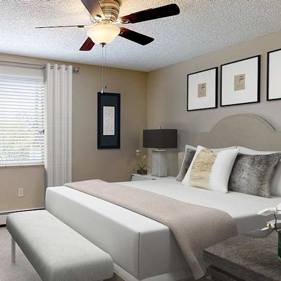 a bedroom with a bed, a bench, and a ceiling fan.