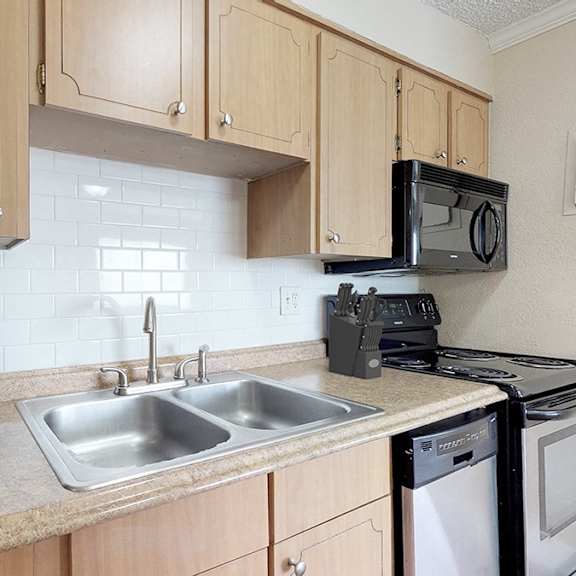 a kitchen with a black refrigerator, a black microwave, a black oven, and a black dishwasher.
