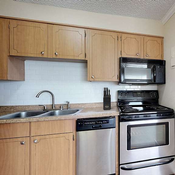a kitchen with wooden cabinets and a stove top oven.
