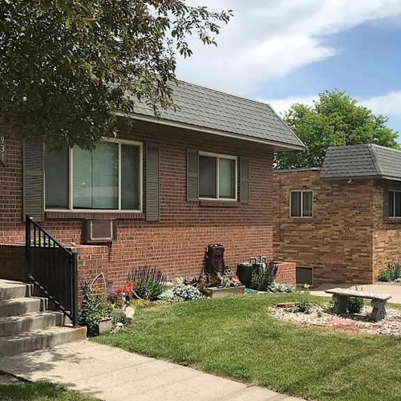 a brick house with a front yard and a tree.