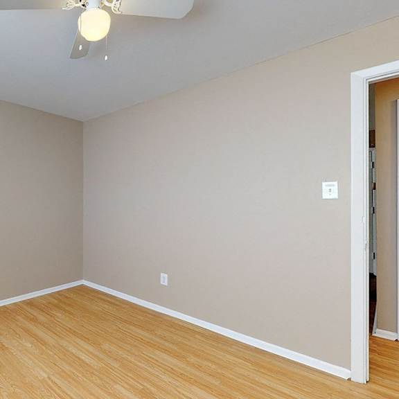 a room with wooden flooring and a ceiling fan.