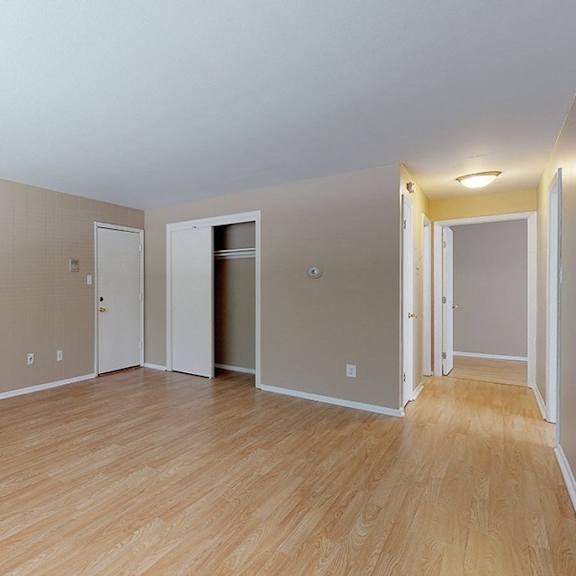 empty room with wooden floors and white walls.
