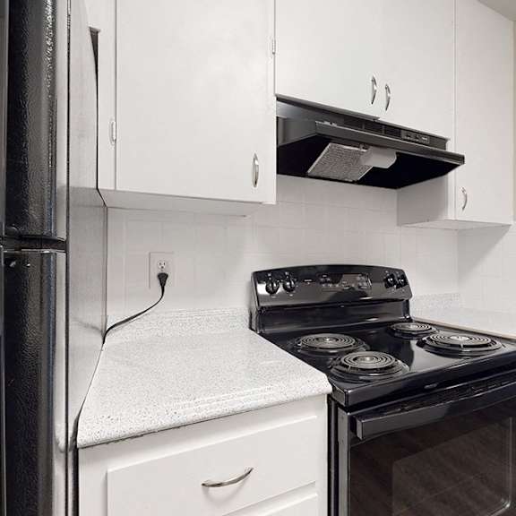 a black stove in a white kitchen.