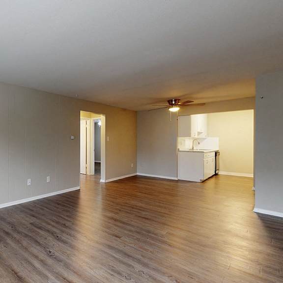 a room with wood flooring and a white refrigerator.