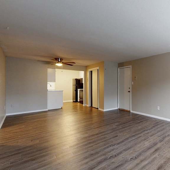 a room with wooden floors and a window on the right side.