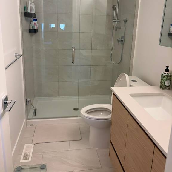 a white toilet in a glass shower room.
