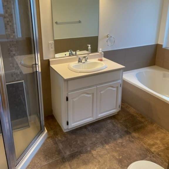 a bathroom with a sink, mirror, and tub.