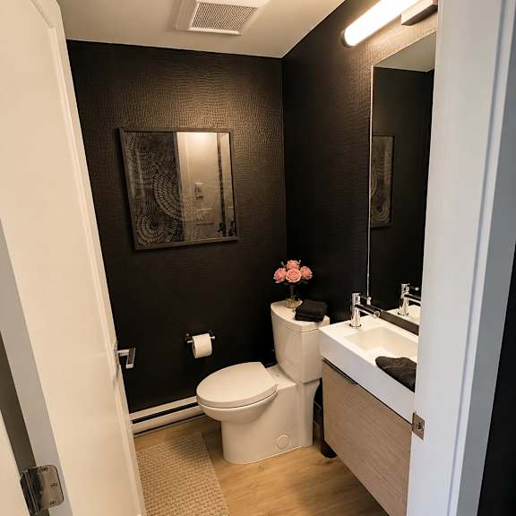 a bathroom with a toilet, sink, and mirror.