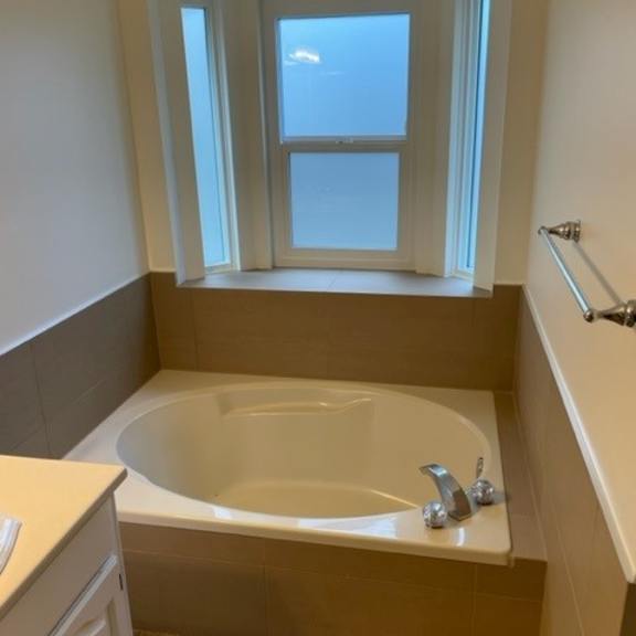 a bathroom with a tub and a window.