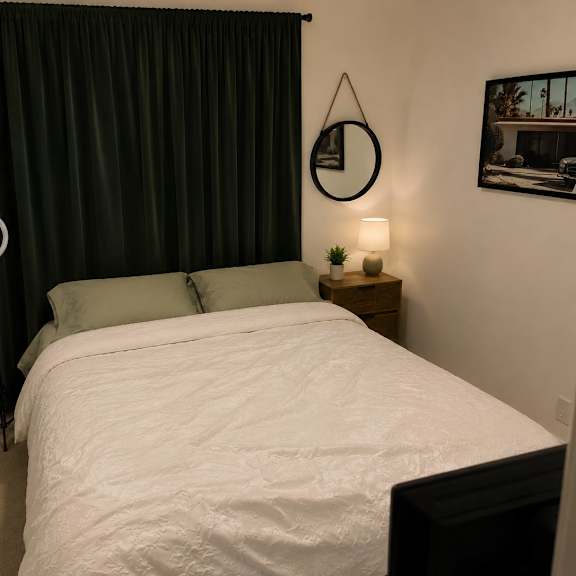 a bedroom with a white bed and green pillows.