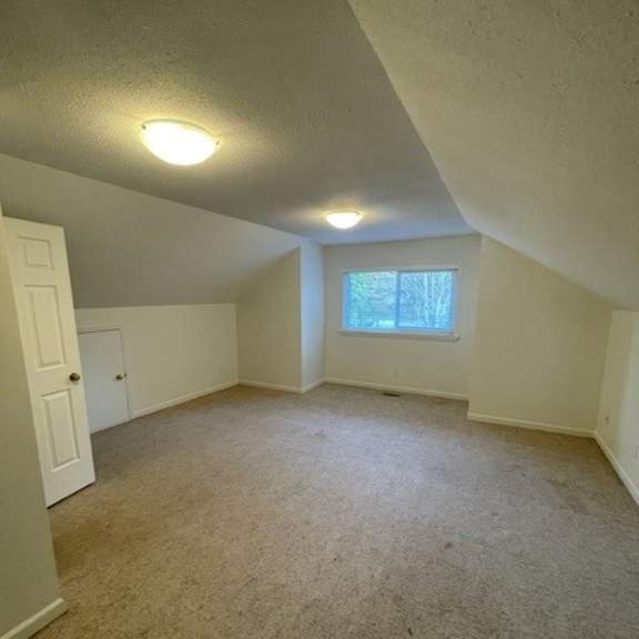 a room with a carpeted floor and a window.