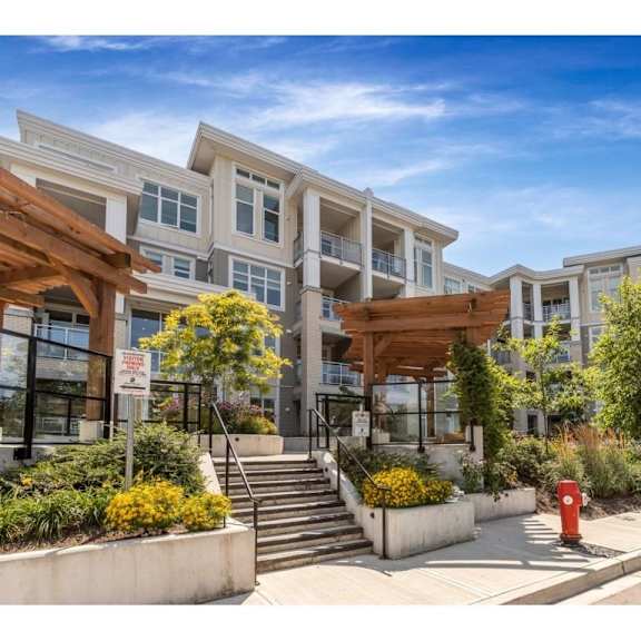 a modern apartment complex with a landscaped entrance.