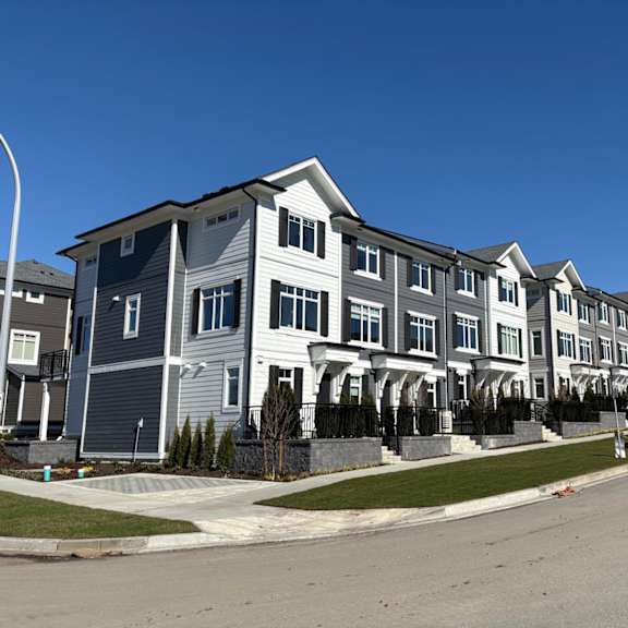 a row of townhouses with a clear blue sky above.