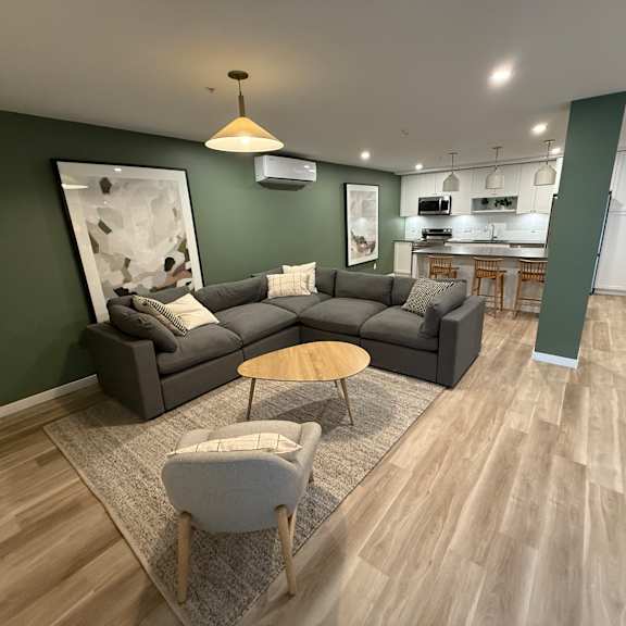 a modern living room with a grey sofa and a wooden coffee table.