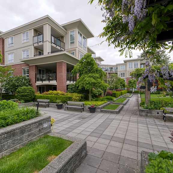 a large building with a patio and a wall in front of it.