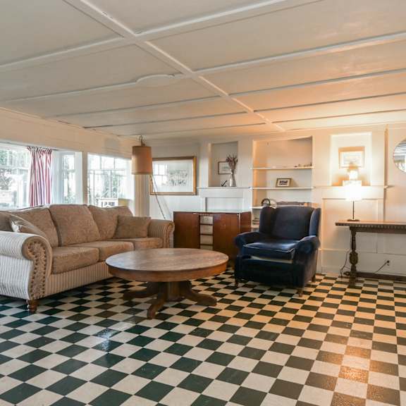 a living room with a checkered floor and a fireplace.