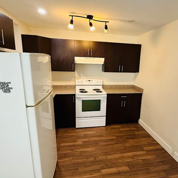 a kitchen with white appliances and dark wood cabinets.