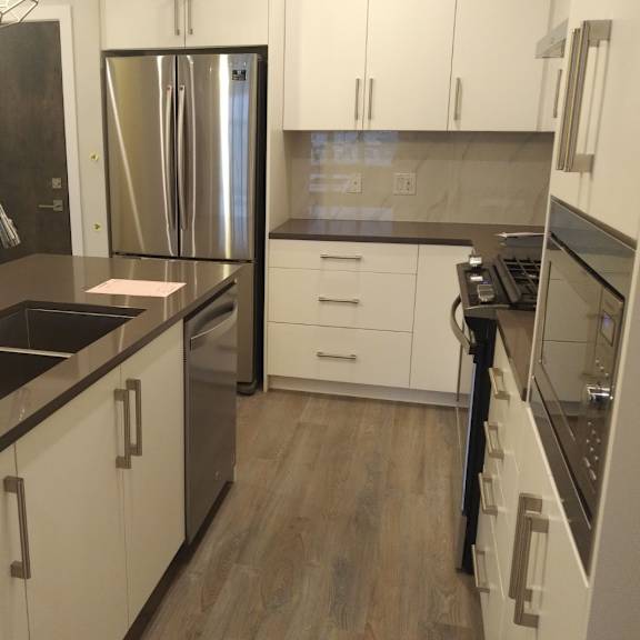 a kitchen with a sink, refrigerator, and stove.