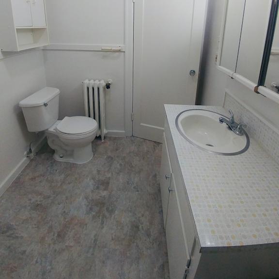 a bathroom with a toilet, sink, and medicine cabinet.