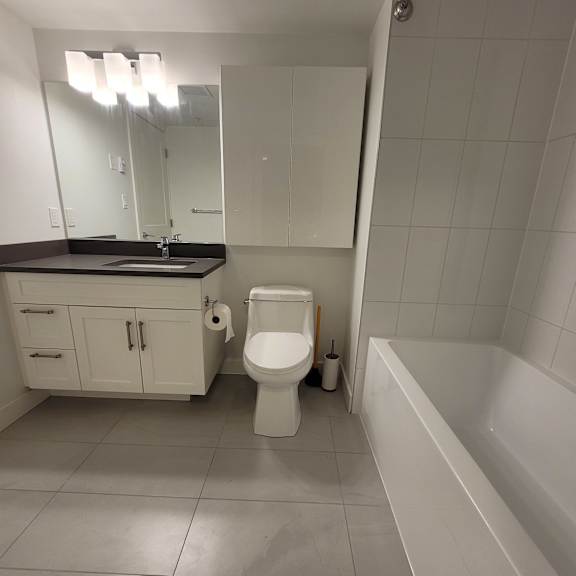 a white bathroom with a toilet and a mirror.