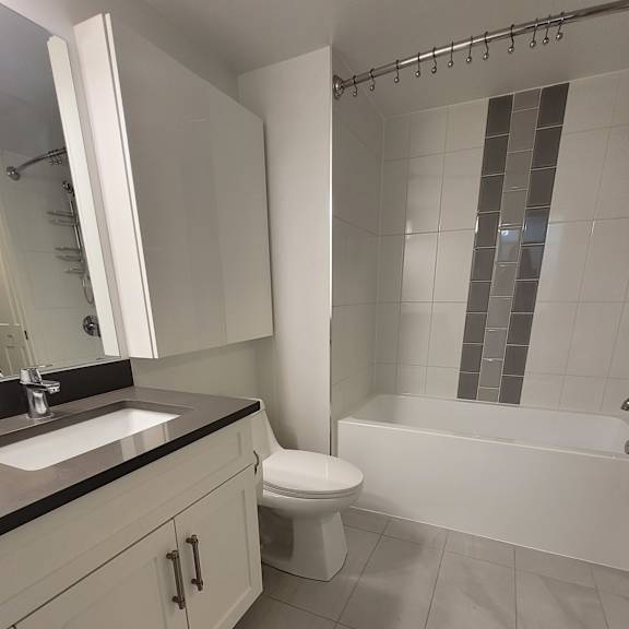 a white toilet with a white cabinet and a white shower tray.