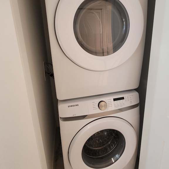 three white samsung washing machines are lined up on a shelf.