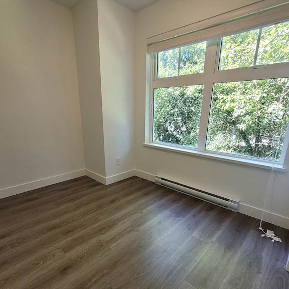 a room with a window and a wooden floor.