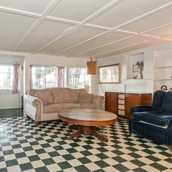 a living room with a checkered floor and a blue couch.