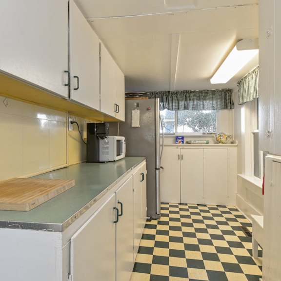 a kitchen with white cabinets and a checkered floor.