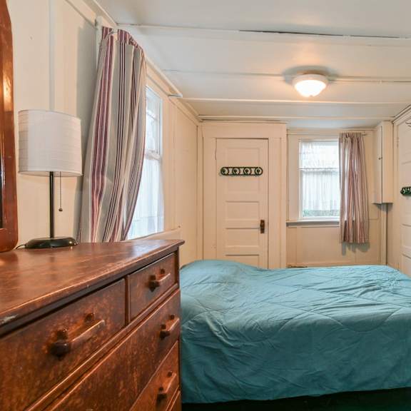 a bedroom with a bed, dresser, and window.