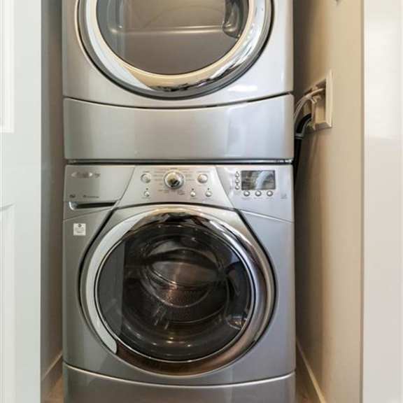 a stack of two front loading washing machines.