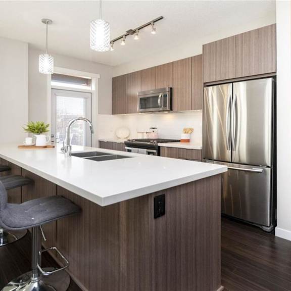 a modern kitchen with a large island and stainless steel appliances.