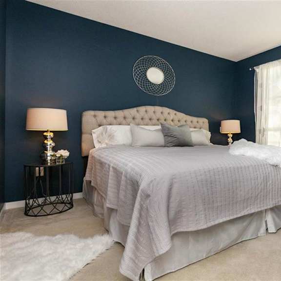 a bedroom with a large bed and a white bedside table.