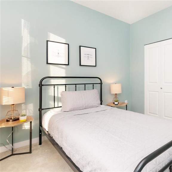 a bedroom with a bed, nightstands, and pictures on the wall.