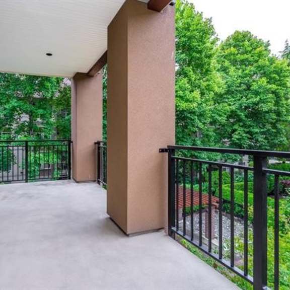 a patio with a black railing and a white ceiling.