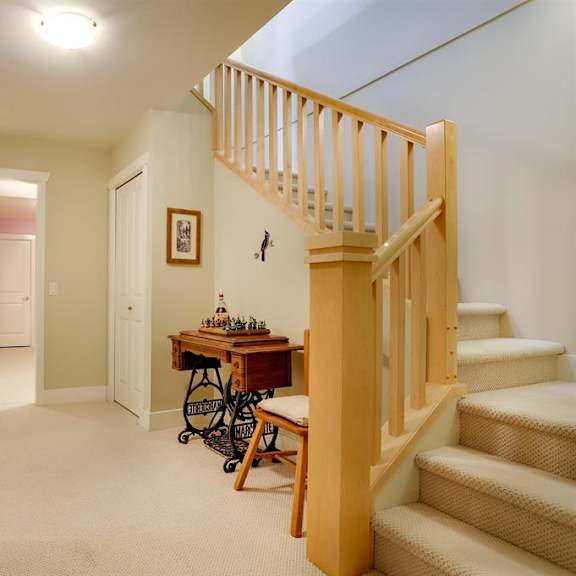 a hallway with a staircase and a table with chairs.