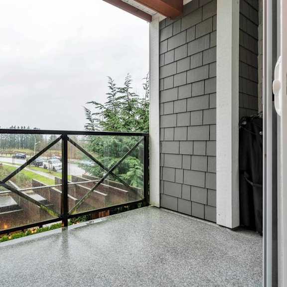 a balcony with a view of a parking lot and trees.