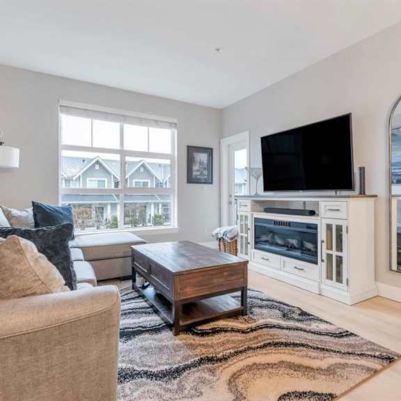 a living room with a brown sofa and a wooden coffee table.