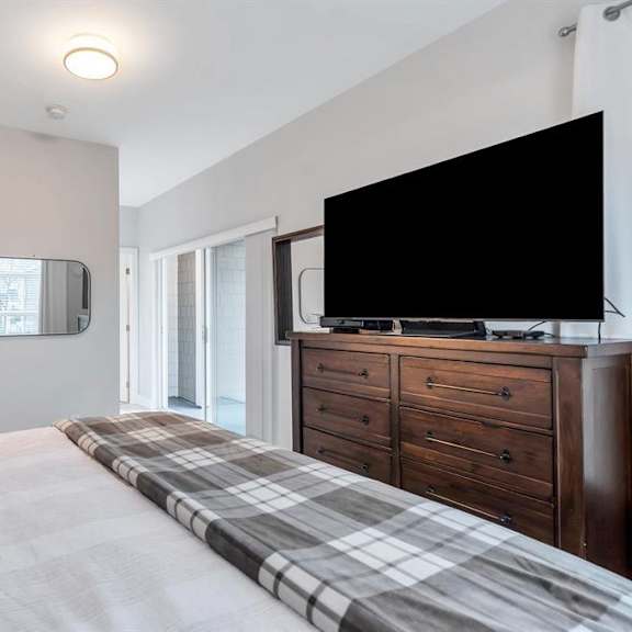 a bedroom with a large bed and a flat screen tv mounted on the wall.