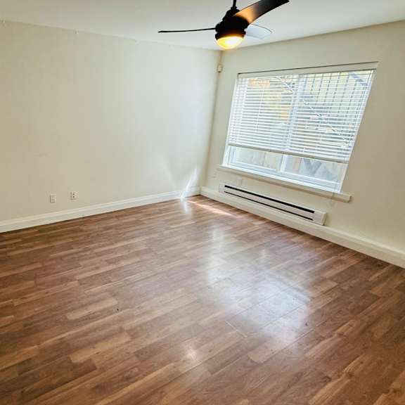 a room with wooden flooring and a ceiling fan.