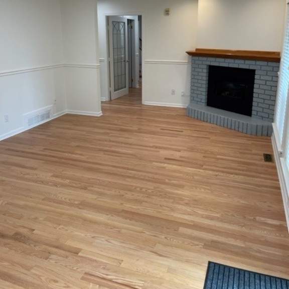 a room with a fireplace and wooden flooring.