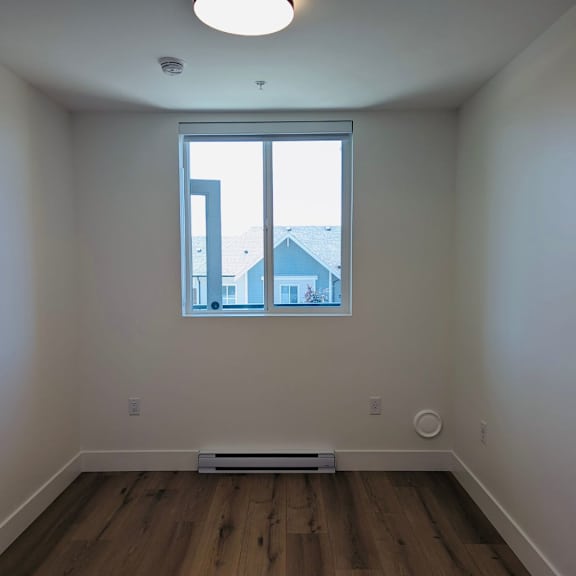 a room with a window and a white wall.
