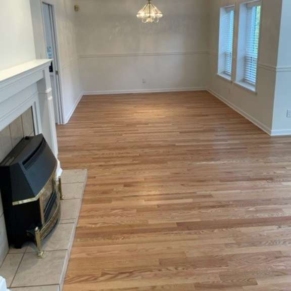 a room with wooden flooring and a fireplace.