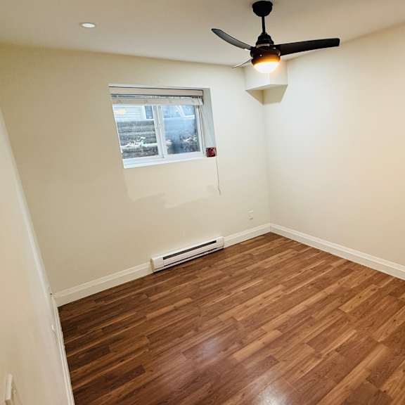 a room with a ceiling fan and a window.