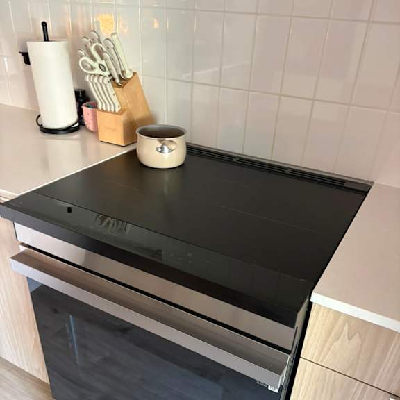 a modern kitchen with a black countertop and wooden cabinets.