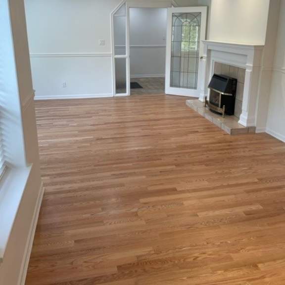 a room with wooden flooring and a fireplace.