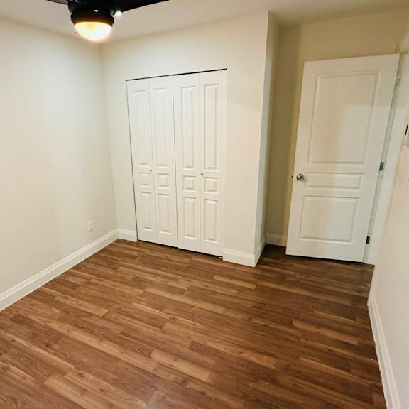 a room with a wooden floor and a white door.