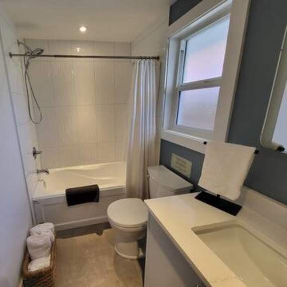 a bathroom with a toilet, sink, and bathtub.