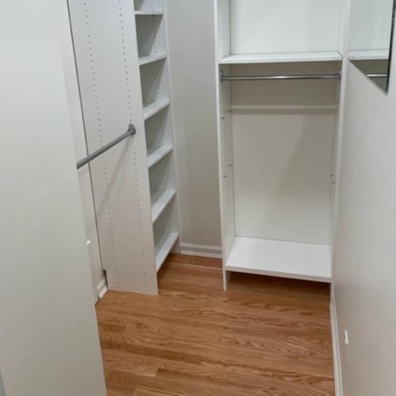 a white pantry with shelves and a door open.