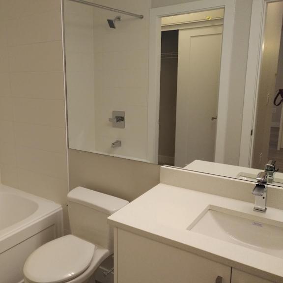 a white bathroom with a toilet, sink, and bathtub.